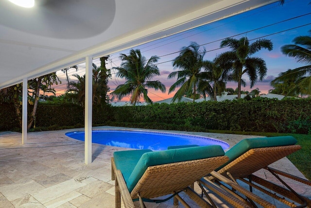 pool at dusk featuring a patio area