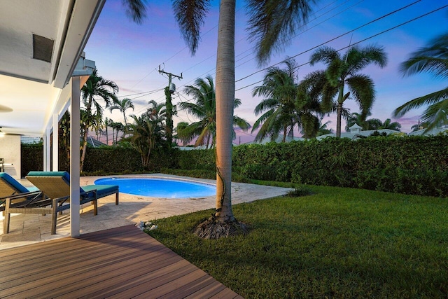 pool at dusk with a lawn and a patio