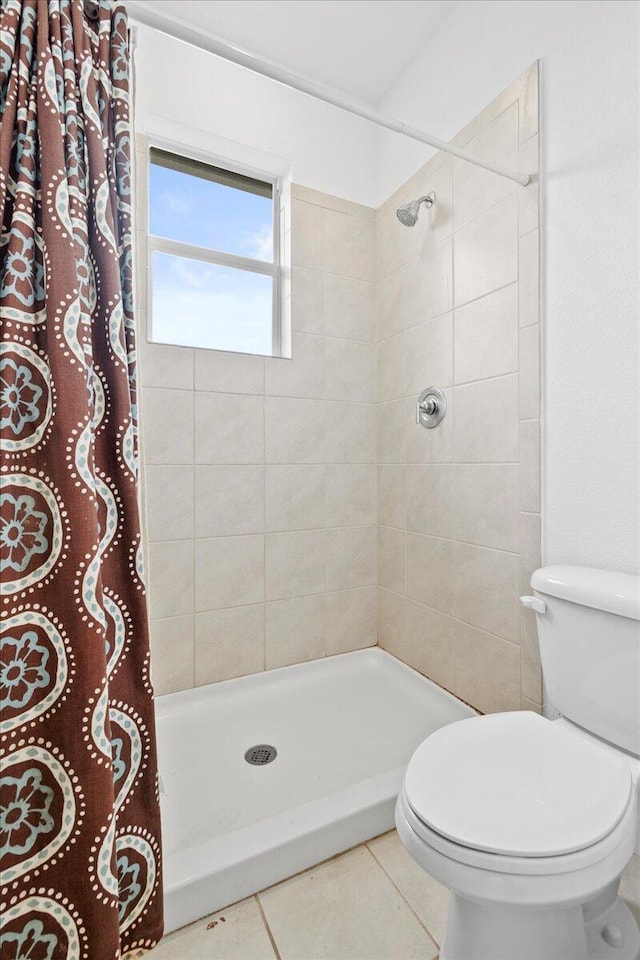 bathroom featuring toilet, tile patterned floors, and walk in shower