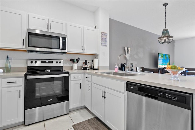 kitchen with white cabinets, stainless steel appliances, sink, and pendant lighting