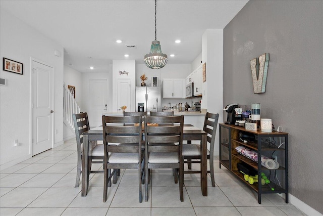 tiled dining area with a chandelier