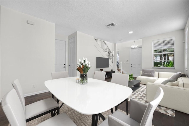 dining room featuring a textured ceiling and wood-type flooring