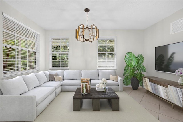 living room featuring a notable chandelier, a wealth of natural light, and light tile patterned floors