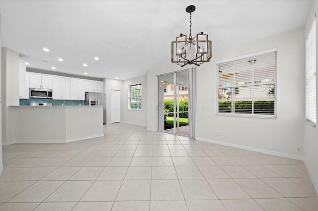 interior space featuring a notable chandelier, a wealth of natural light, and light tile patterned flooring