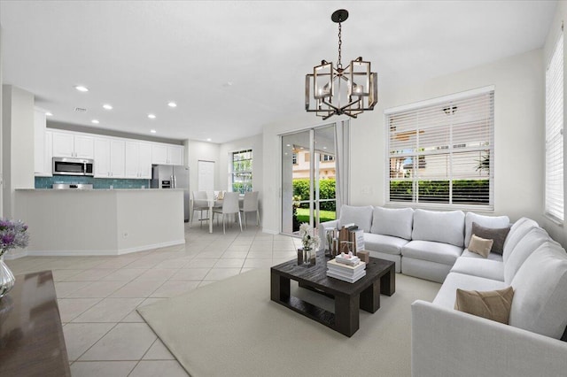 tiled living room featuring plenty of natural light and a chandelier