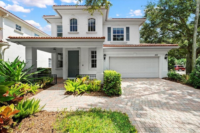 mediterranean / spanish-style house featuring a garage and covered porch