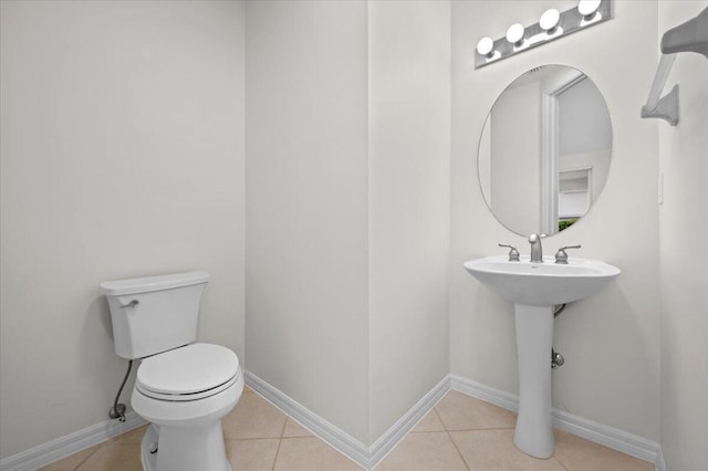 bathroom with toilet and tile patterned floors