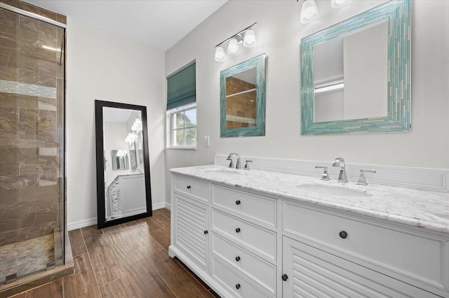 bathroom with wood-type flooring, walk in shower, and vanity