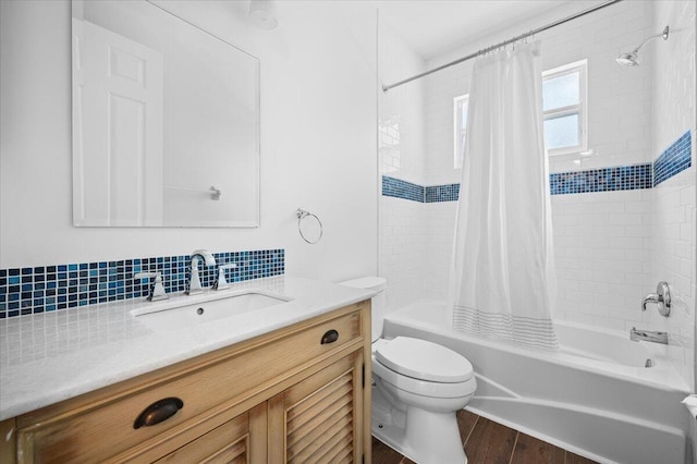 full bathroom featuring hardwood / wood-style flooring, tasteful backsplash, shower / tub combo with curtain, vanity, and toilet