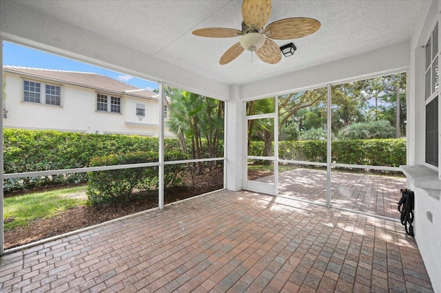 unfurnished sunroom featuring ceiling fan