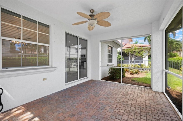 unfurnished sunroom with ceiling fan