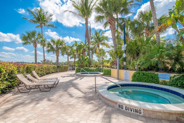 view of swimming pool with a hot tub