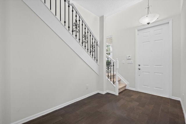 entrance foyer with a textured ceiling and dark hardwood / wood-style floors