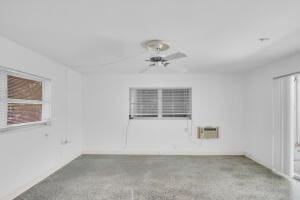 empty room with ceiling fan and an AC wall unit