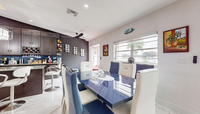 dining room with ceiling fan and vaulted ceiling