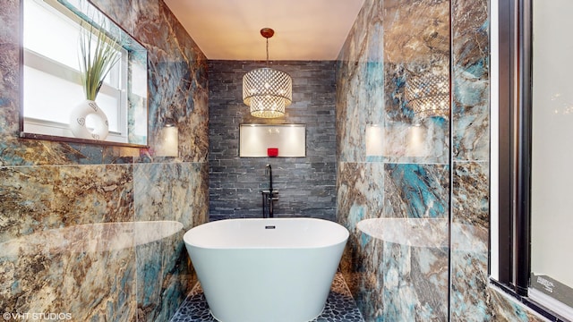 bathroom featuring a tub to relax in and tile walls