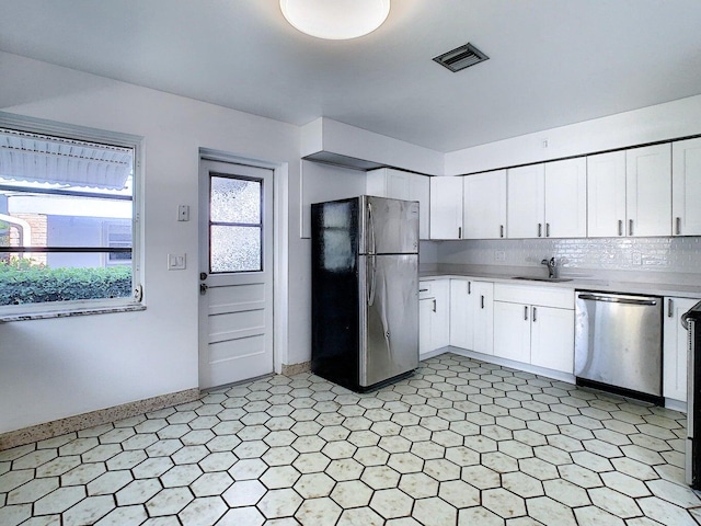 kitchen featuring appliances with stainless steel finishes, backsplash, white cabinetry, and sink