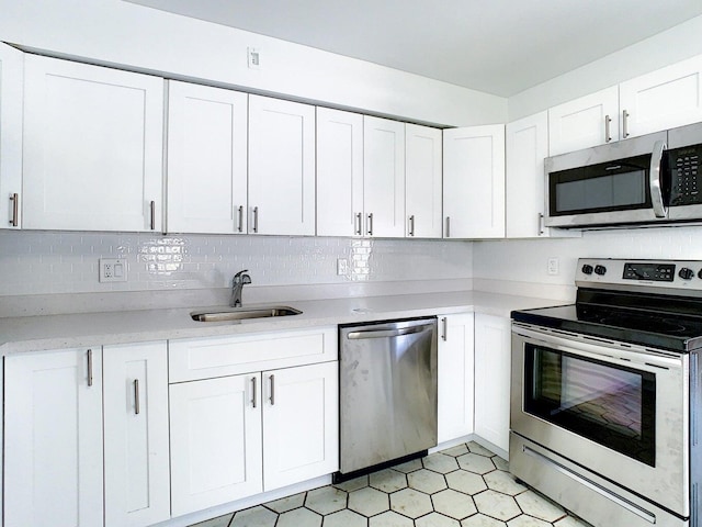 kitchen with appliances with stainless steel finishes, sink, and white cabinets