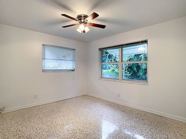 unfurnished room featuring a healthy amount of sunlight and ceiling fan