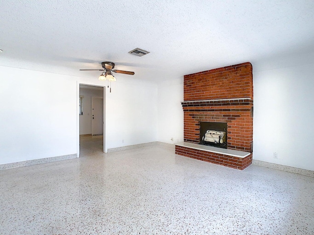 unfurnished living room with a brick fireplace, a textured ceiling, and ceiling fan