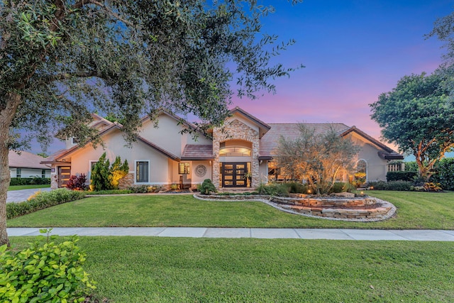 view of front of home featuring french doors and a yard