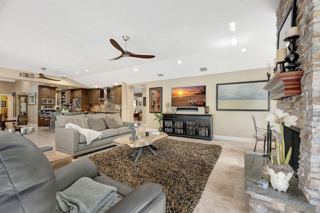 living room with ceiling fan and a fireplace