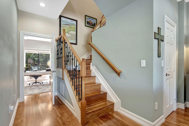 stairs featuring wood-type flooring and lofted ceiling