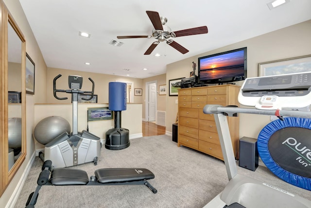 exercise area with ceiling fan and light colored carpet