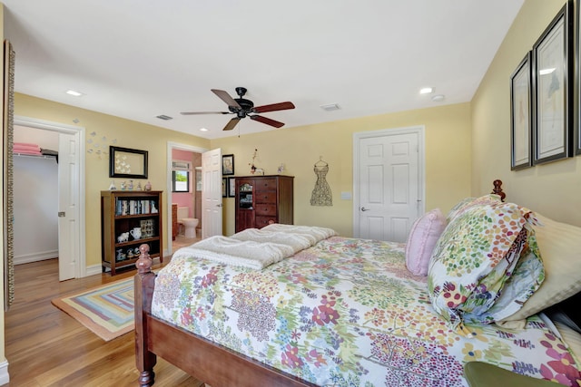 bedroom featuring light hardwood / wood-style floors, ceiling fan, and ensuite bathroom