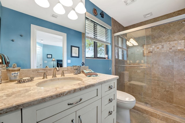 bathroom with vanity, a shower with shower door, and toilet