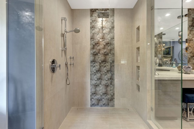 bathroom featuring tile walls, vanity, tile patterned flooring, and a shower with shower door