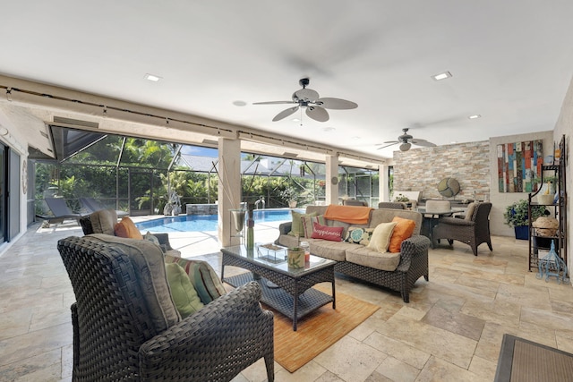 view of patio / terrace featuring a lanai, pool water feature, ceiling fan, and outdoor lounge area