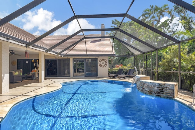 view of pool featuring glass enclosure, a jacuzzi, ceiling fan, a patio area, and pool water feature