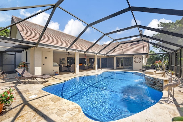 view of pool with pool water feature, glass enclosure, and a patio area