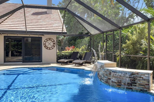 view of pool with glass enclosure, a patio area, and pool water feature