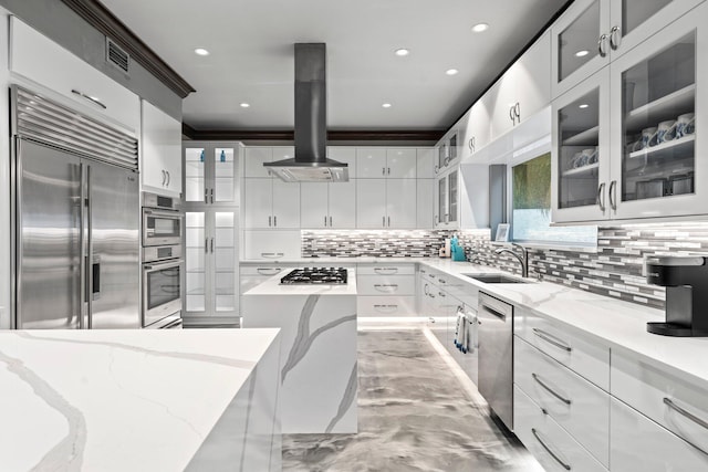 kitchen with sink, appliances with stainless steel finishes, wall chimney range hood, and white cabinetry