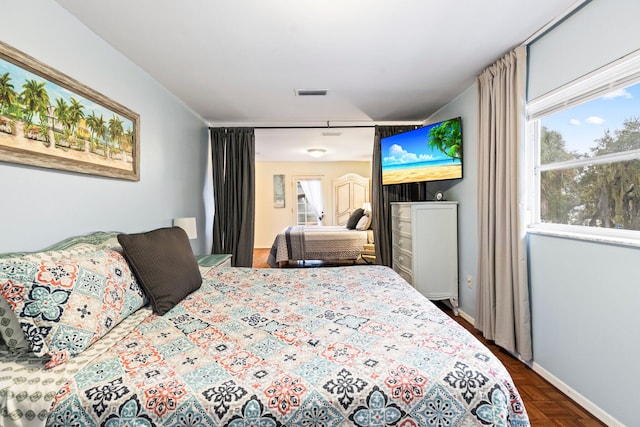 bedroom featuring parquet flooring and multiple windows