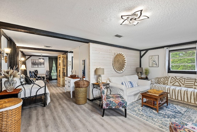 living room featuring hardwood / wood-style floors, a textured ceiling, and wood walls