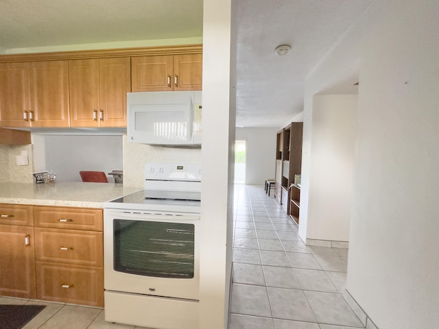 kitchen with light tile patterned floors and white appliances