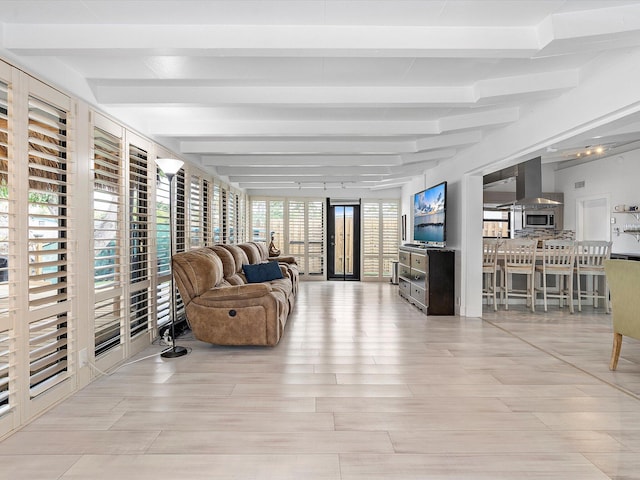 living room featuring beamed ceiling and light hardwood / wood-style floors