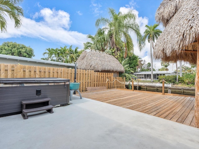 wooden terrace with a gazebo, a patio area, and a hot tub