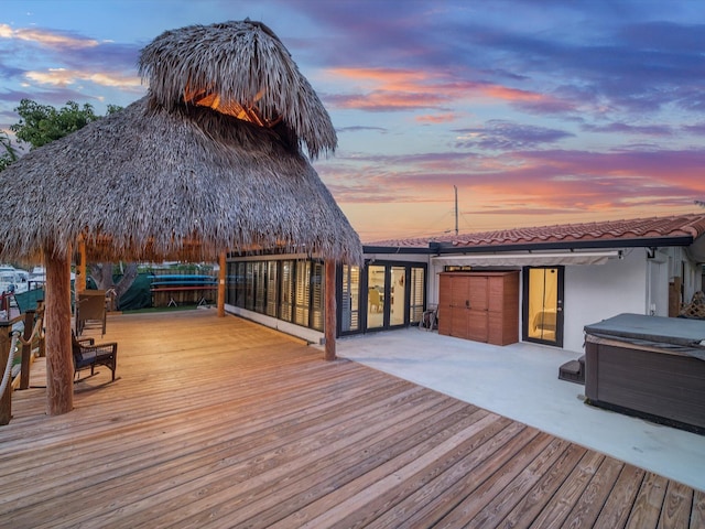 deck at dusk featuring a gazebo