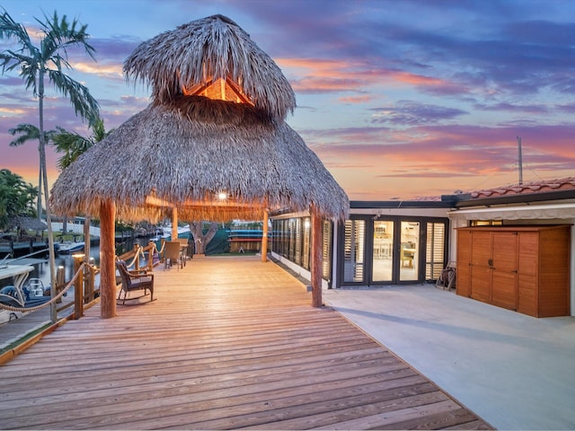 deck at dusk featuring a boat dock