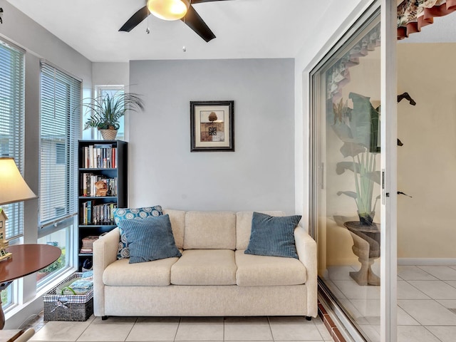 living room featuring light tile patterned floors, baseboards, and ceiling fan