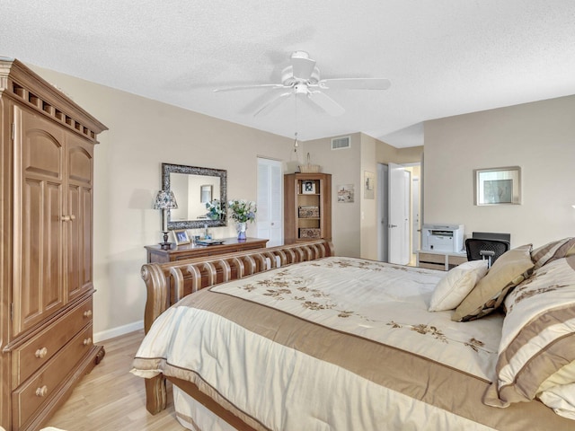 bedroom with ceiling fan, a textured ceiling, and light wood-type flooring