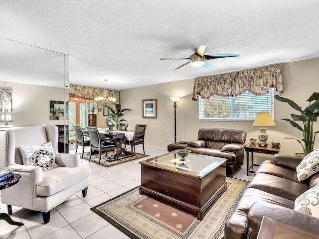 living room with light tile patterned floors, ceiling fan with notable chandelier, and a textured ceiling