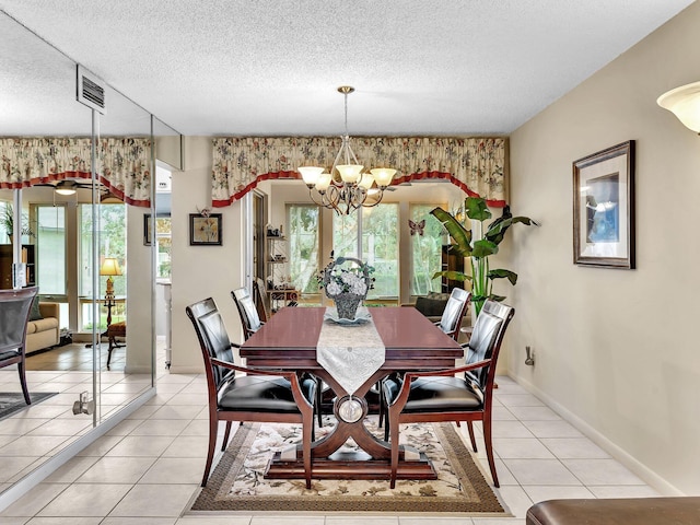 dining space with a wealth of natural light, a notable chandelier, a textured ceiling, and light tile patterned flooring