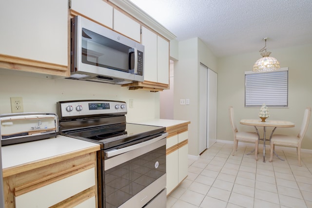 kitchen featuring hanging light fixtures, white cabinetry, light tile patterned floors, stainless steel appliances, and a textured ceiling