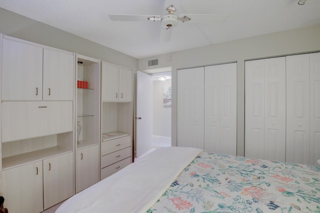 bedroom featuring ceiling fan and multiple closets