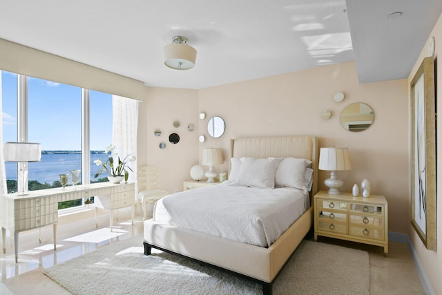 bedroom with a water view and multiple windows